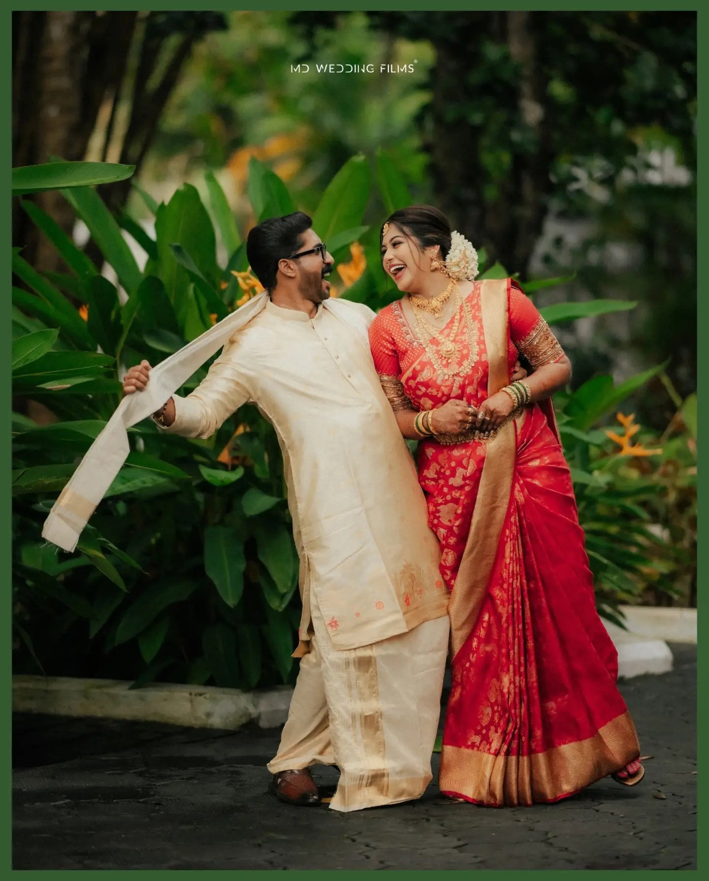 Newlyweds laughing together among tropical greenery